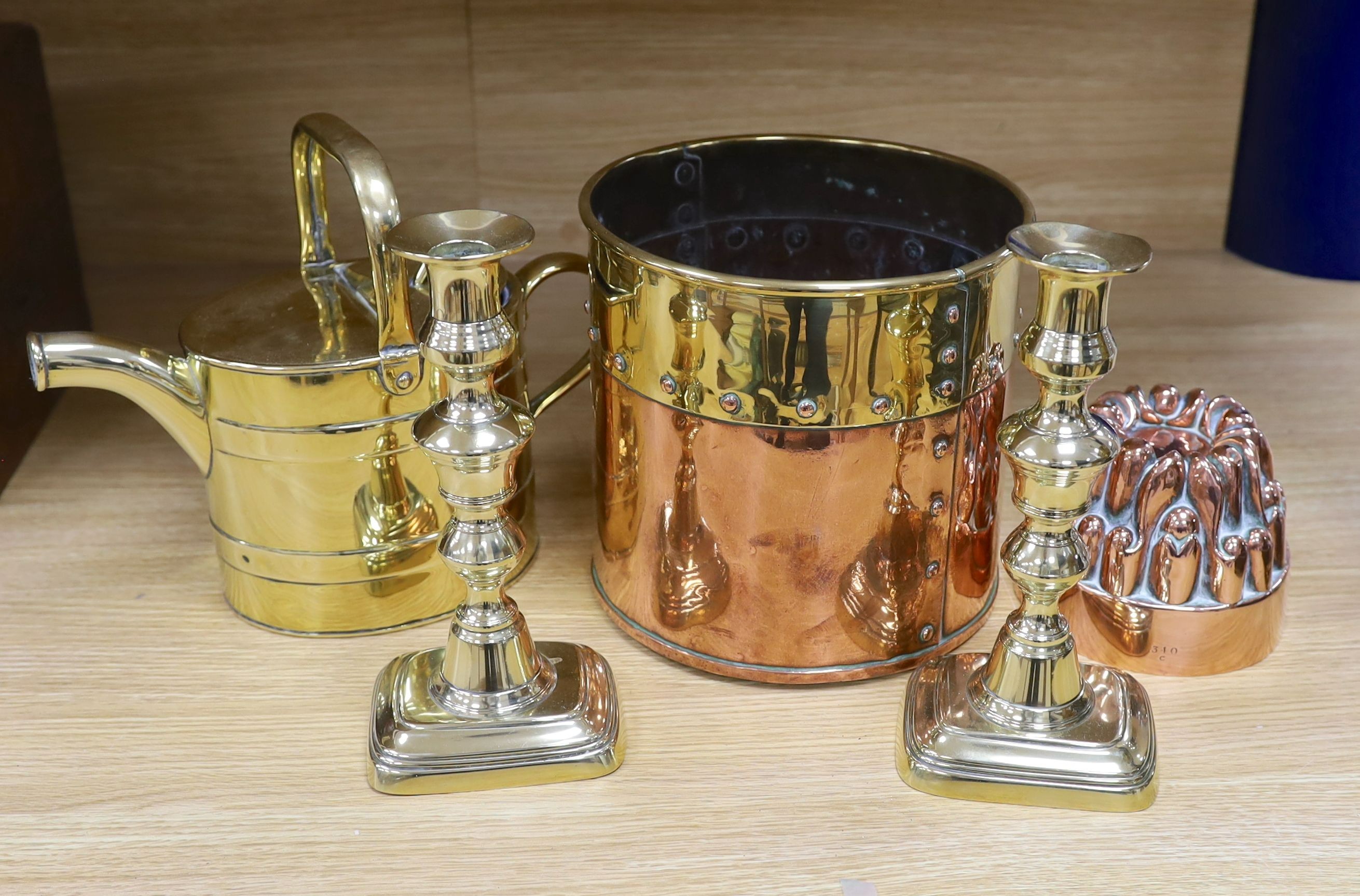 A Victorian copper jelly mould, pair of Victorian brass candlesticks 23cm, a brass water kettle, and a brass copper jardinière